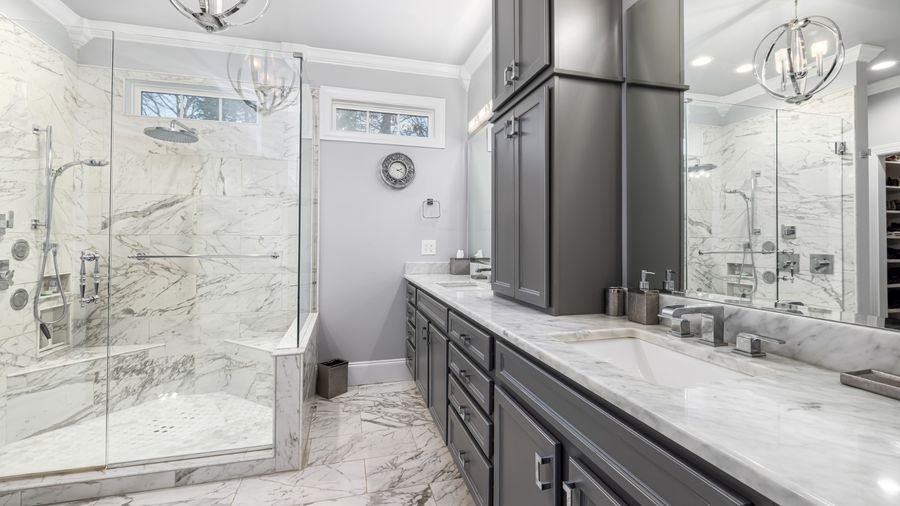 Remodeled bathroom with marble tile and glass shower