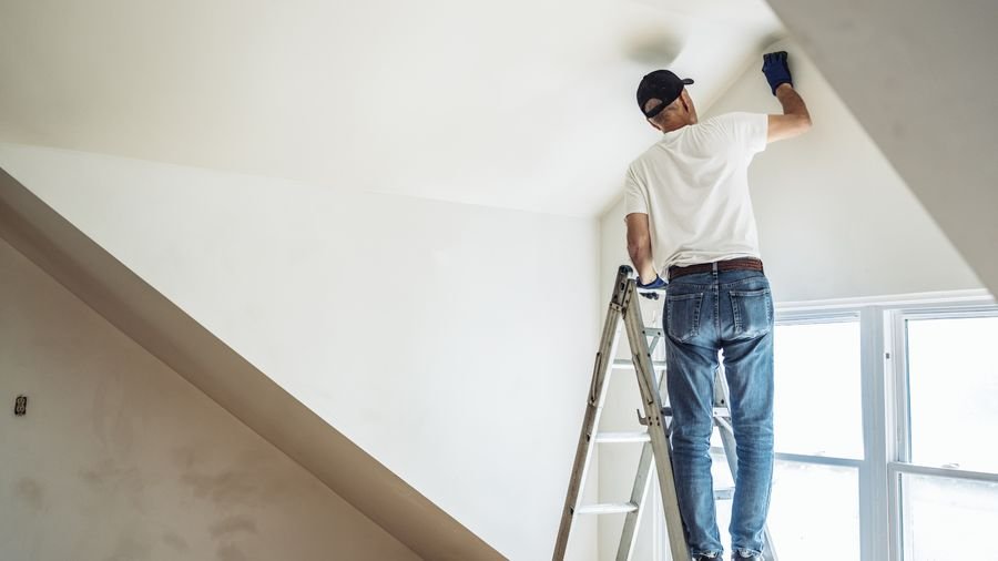 Painter finishing an interior ceiling during a remodel
